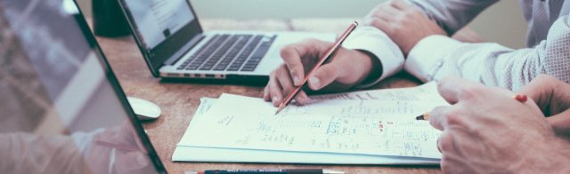Two people consulting over paperwork